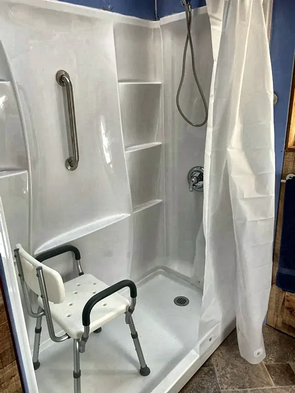 Walk-in shower with grab bar by Brown Sterling Builders
