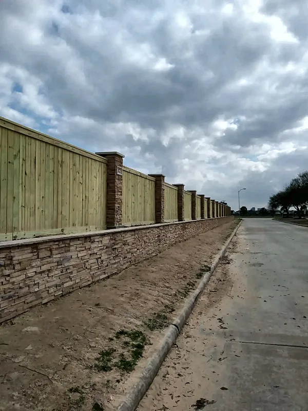 Wood fence with stone columns by Brown Sterling Builders