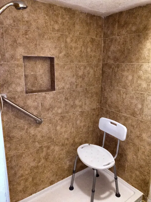 Accessible tile shower with grab bar and shower seat
