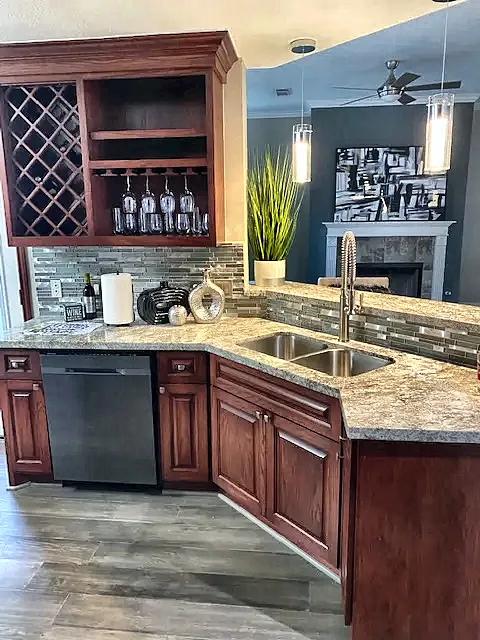 Kitchen remodel with cherry cabinets, granite counters and glass tile backsplash by Brown Sterling Builders